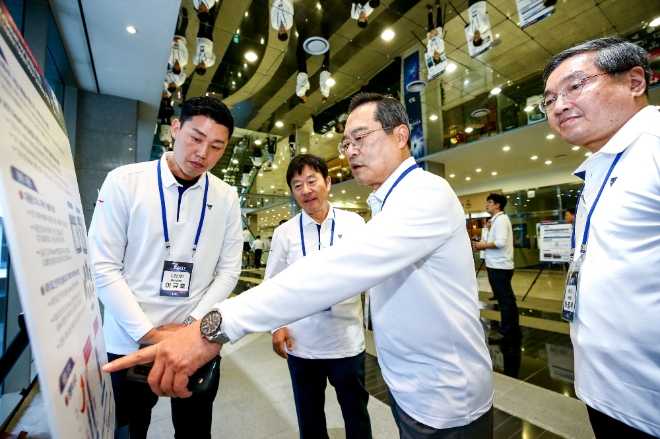 구자열 LS그룹 회장(사진 왼쪽에서 3번째)이 안양 LS타워에서 개최된 ‘LS T-Fair 2019’에서 우수과제로 선정된 기술에 대한 설명을 듣고 있다.