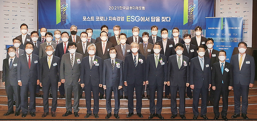 ▲ 5월 11일 서울 은행회관 2층 국제회의실에서 열린 한국금융신문 주최 ‘2021 한국금융미래포럼’ 행사에서 은성수 금융위원장(첫째 줄 오른쪽 다섯번째) 등 금융권 30여명의 최고 리더들이 마스크를 쓰고 기념촬영을 하고 있다. 이날 포럼 행사는 사회적 거리두기 취지에 맞게 좌석을 띄었고 발열 및 체온 체크와, 마스크 상시 착용, 1시간마다 10분 휴식 등 방역절차를 이행했다. 기념사진 첫 번째 줄 왼쪽부터 김봉국 한국금융신문 대표이사 사장, 김지완 BNK금융지주 회장, 윤종규 KB금융지주 회장, 윤창현 국민의 힘 의원, 홍성국 더불어민주당 의원, 허과현 한국금융신문 회장, 임종룡 전 금융위원장(현 법무법인 율촌 고문), 은성수 금융위원장, 이형희 SK수펙스추구협의회 SV위원장, 정희수 생명보험협회장, 정지원 손해보험협회장, 이명호 한국예탁결제원 사장, 둘째 줄 왼쪽부터 홍우선 코스콤 사장, 박재식 저축은행중앙회장, 유광열 SGI서울보증보험 사장, 나재철 금융투자협회장, 조용병 신한금융지주 회장, 손태승 우리금융지주 회장, 김광수 전국은행연합회장, 원종현 국민연금 수탁자책임전문위원회 위원장, 류영준 핀테크산업협회장, 송병운 에프앤가이드 ESG센터장, 윤진수 기업지배구조원 본부장, 마지막 줄 왼쪽부터 이호동 한국기업데이터 대표, 서정동 DGB캐피탈 사장, 이윤배 화재보험협회 이사장, 신현준 한국신용정보원장, 윤규선 하나캐피탈 사장, 김주현 여신금융협회장, 김근수 신용정보협회장, 임승보 대부금융협회장, 김진균 sh수협은행장, 윤용희 법무법인 율촌 ESG전담 변호사, 장윤재 국민연금 박사.