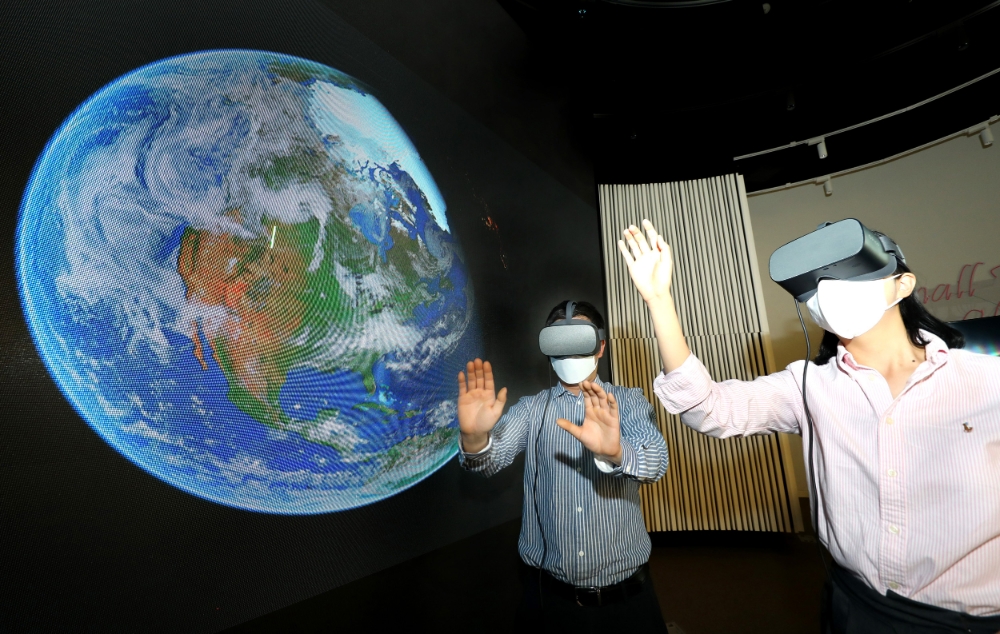 LG유플러스 관계자들이 우주를 배경으로 한 스튜디오에서 U+VR의 신규 콘텐츠를 감상하는 모습. 사진=LG유플러스