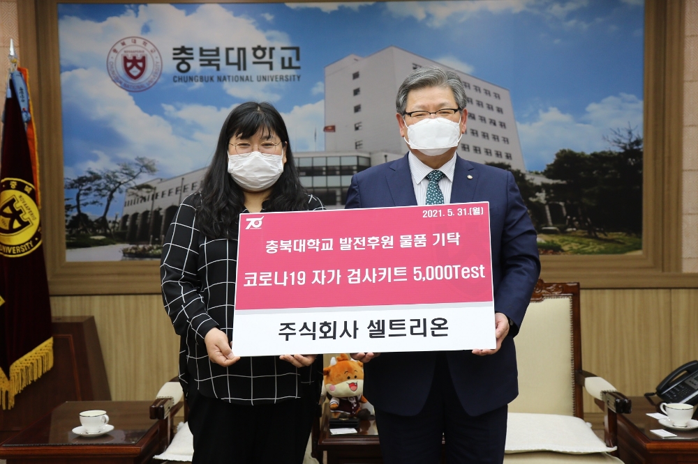 양현주 셀트리온 글로벌SCM본부장이(왼쪽)이 김수갑 충북대학교 총장에게 코로나19 자가검사키트 디아트러스트 홈 테스트 5000개를 전달하고 있다. 사진=충북대학교