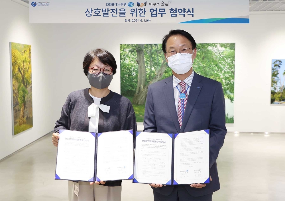 김영운 DGB대구은행 본부장(오른쪽)과 최은주 대구미술관장이 1일 대구 수성동 본점에서 지역 문화발전과 차별화한 고객 서비스 제공을 위해 수성동 본점에서 업무협약을 체결한 뒤 기념촬영을 하고 있다./사진=DGB대구은행
