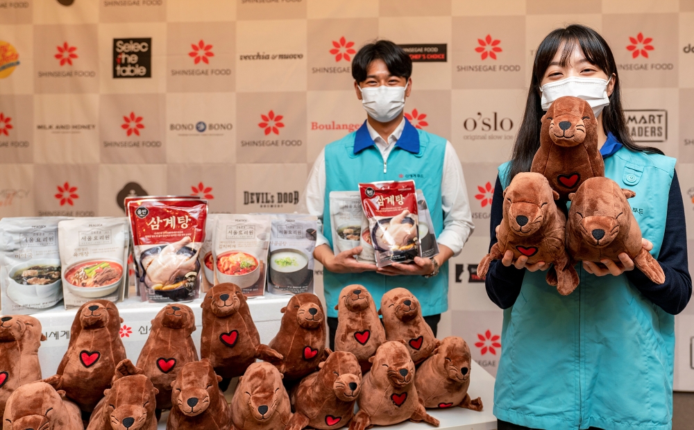 3일 서울시 성동구 신세계푸드 본사에서 신세계푸드 임직원들이 버려지는 페트병을 재가공한 솜으로 직접 만든 업사이클링 강치 인형과 올반 삼계탕 등 국탕류 간편식 세트 100개를 미혼모자시설에 기부했다. / 사진제공 =신세계푸드