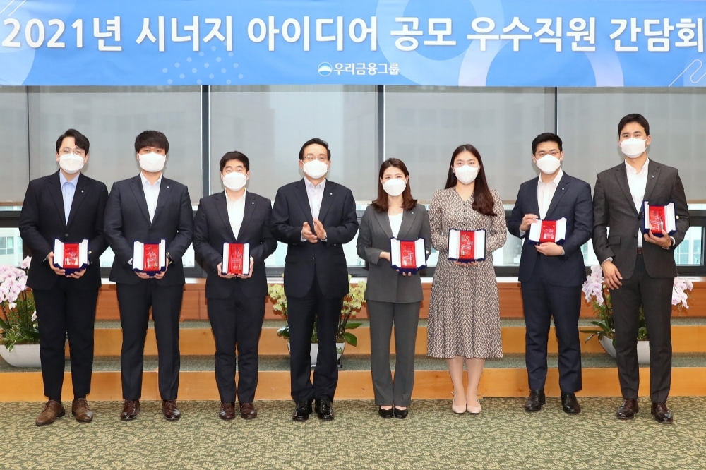 손태승 우리금융그룹 회장(왼쪽 네 번째)이 지난 18일 우리금융 본사에서 '시너지 아이디어 공모전' 시상식에 참석해 우수제안에 최종 선정된 직원들과 기념촬영을 하고 있다./사진=우리금융그룹
