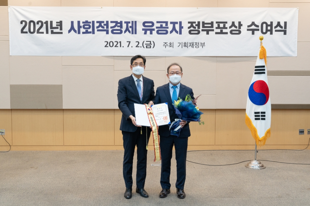 KT&G가 지난 2일 ‘2021 사회적경제 유공자’ 정부포상 수여식에서 대통령 표창을 수상했다. 사진은 이상학 KT&G 지속경영본부장(오른쪽)이 수여식에 참석해 기념촬영을 하고 있는 모습. / 사진제공 = KT&G