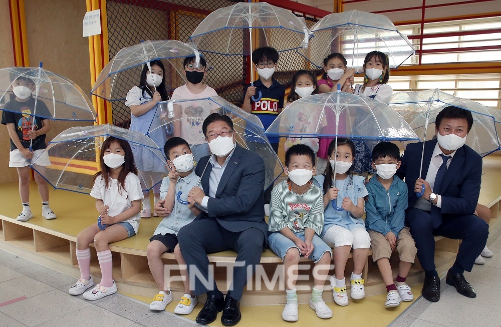 안준식 신한은행 부행장(앞줄 오른쪽에서 다섯 번째)과 정영균 한국어린이안전재단 사무총장(오른쪽 끝)이 지난 6일 서울 중구 서울남산초등학교에서 진행된 '신한마음우산' 기부식에서 학생들과 기념촬영하고 있다./사진=신한은행