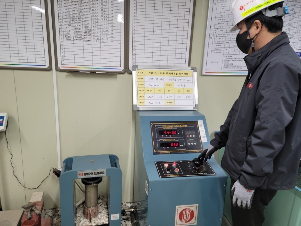 롯데건설이 롯데케미칼, 동남기업과 함께 개발한 화학 혼화제를 현장에 적용해 압축 강도를 테스트하는 모습. / 사진=롯데건설