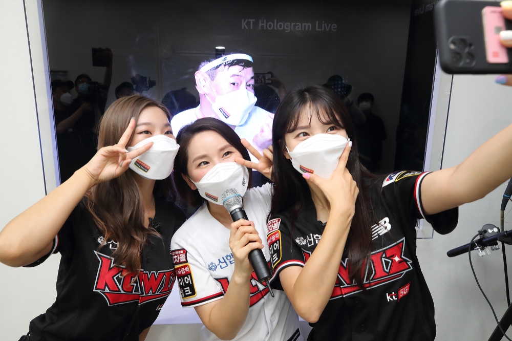 KT 관계자들이 수원 KT 위즈파크내 마련된 28GHz 5G체험관에서 kt wiz 김주일 응원단장과의 실시간 양방향 홀로그램 팬미팅 서비스를 소개하고 있다. 사진=KT