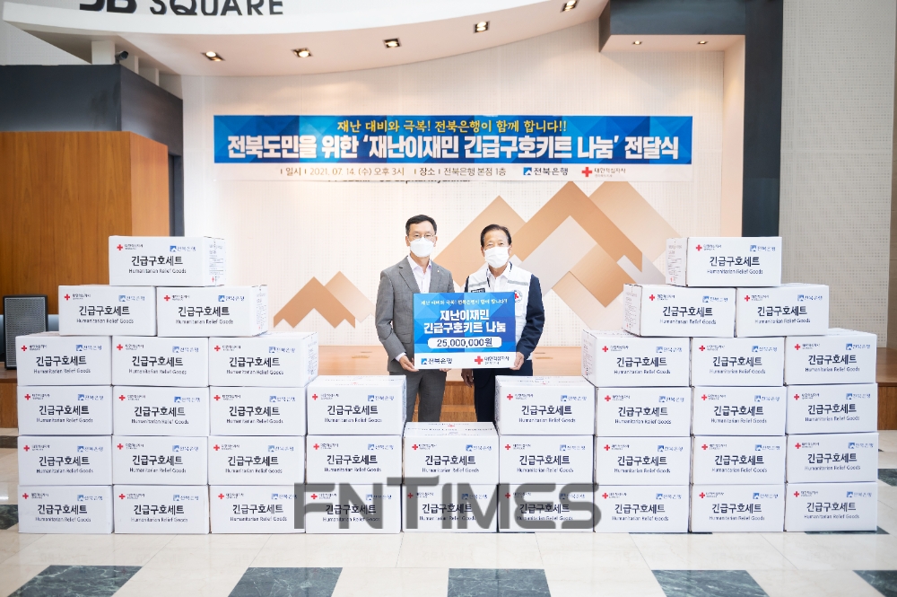 서한국 전북은행장(왼쪽)과 이선홍 대한적십자사 전북지사 회장이 14일 전북은행 본점 1층 로비에서 '재난이재민 긴급구호키트 나눔' 전달식을 연 뒤 기념촬영하고 있다./사진=전북은행