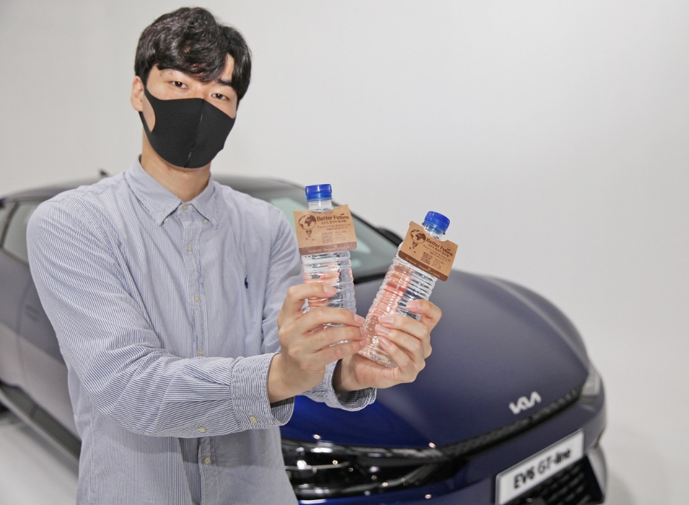 동원F&B 직원이 ‘동원샘물 라벨프리’를 들고 ‘EV6’ 앞에서 사진을 촬영하고 있다. / 사진제공 = 동원그룹