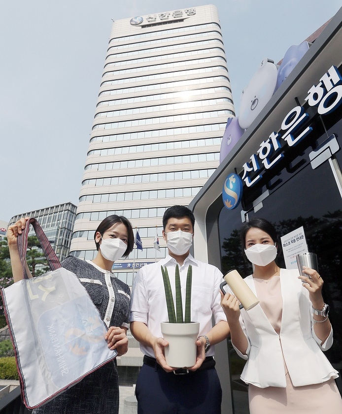 12일 서울 중구에 위치한 신한은행 본점에서 신한은행 직원들이 은행에서 사용했던 각종 폐현수막을 새활용한 장바구니와 공기정화식물인 스투키, 대표적 다회용기인 텀블러를 들고 '신한 ESG 실천 빌딩' 선언에 동참하고 있다./사진=신한은행