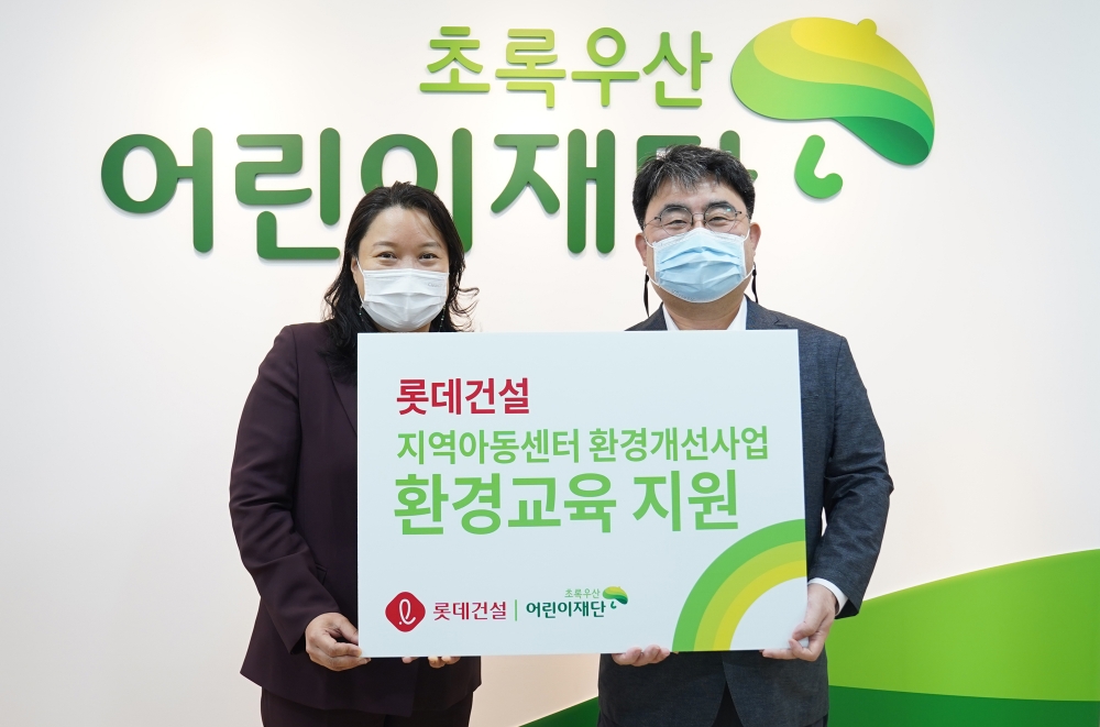 롯데건설 전략기획부문 한정호 상무(우)와 초록우산 어린이재단 최운정 본부장(좌)이 기증판 전달식에서 기념사진을 촬영하고 있다. / 사진제공=롯데건설