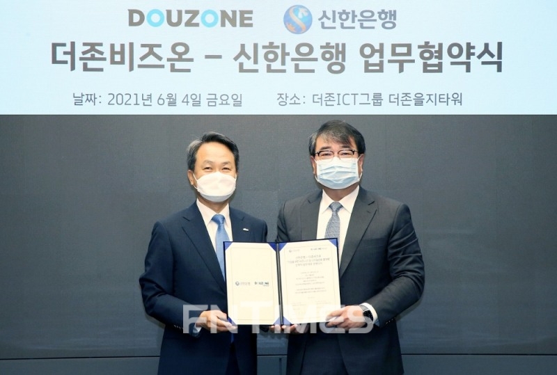 진옥동 신한은행장(왼쪽)과 김용우 더존비즈온 회장이 지난 6월 서울 중구에 위치한 더존을지타워에서 진행된 업무협약식에서 기념촬영을 하고 있다./사진=신한은행