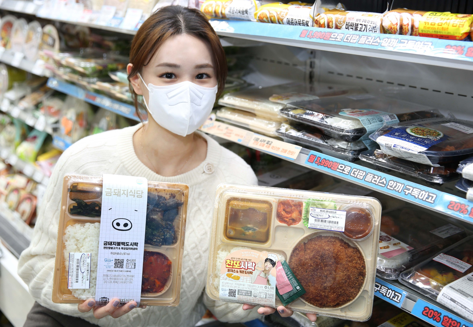 모델이 GS25 금돼지식당 및 이찬원과 컬래버 한 도시락 상품을 들고 포즈를 취하고 있다./사진제공=GS리테일