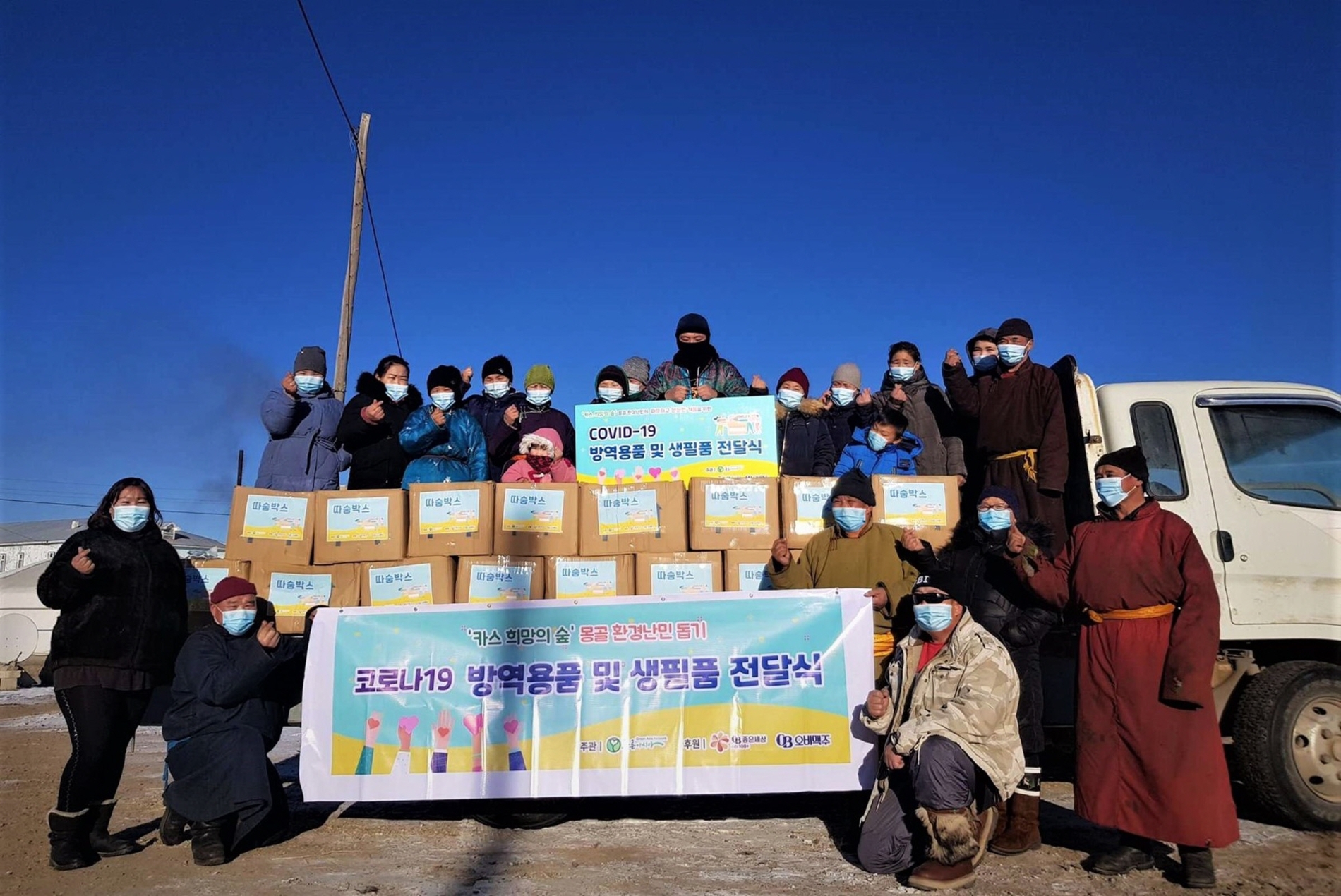 몽골 카스 희망의 숲 인근 하늘마을 주민들이 푸른아시아의 현지 활동가와 따숨박스 전달식에 참석해 기념사진을 찍고 있다./ 사진제공 = 오비맥주
