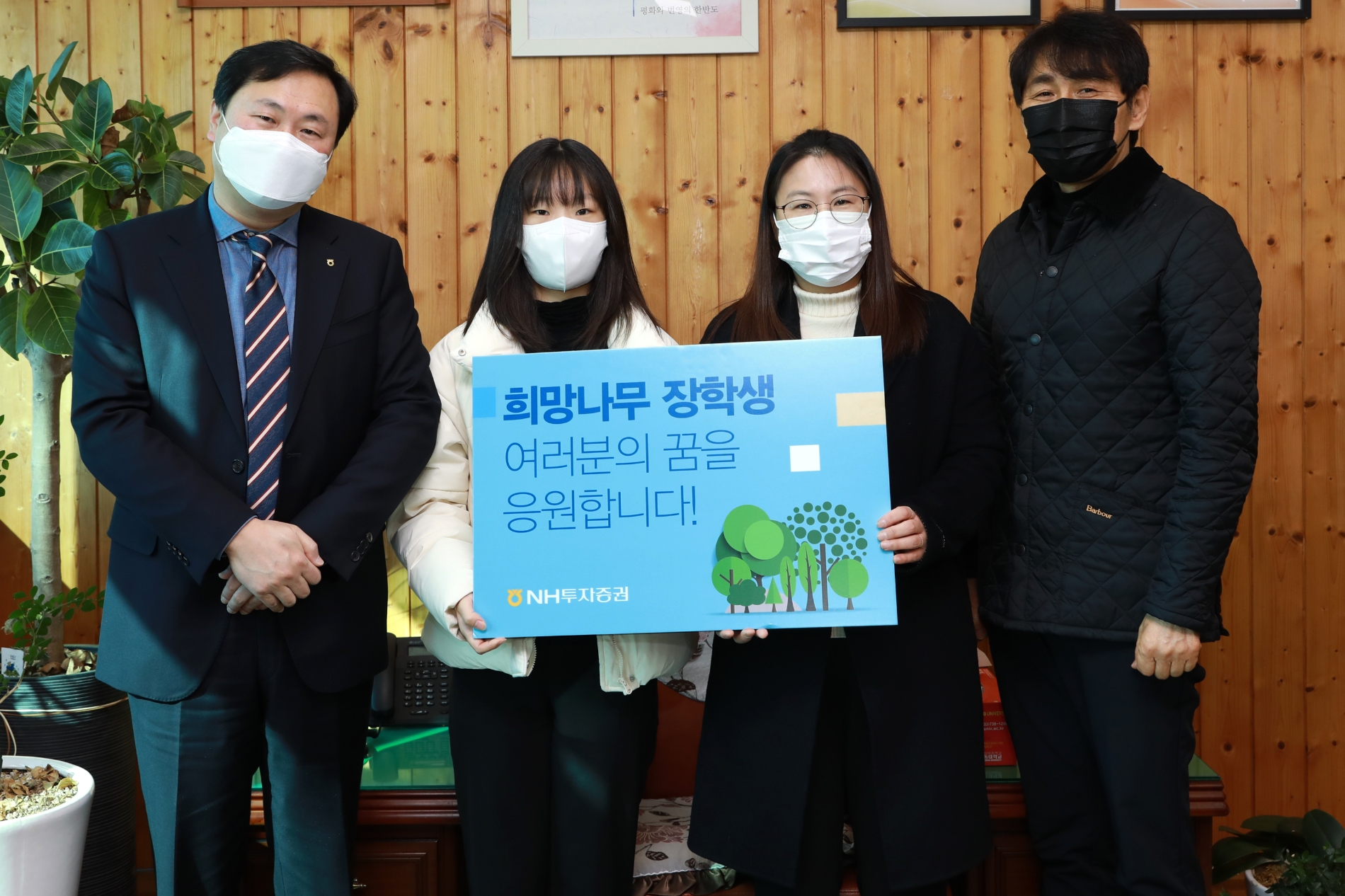 NH투자증권은 17일 경기도 전곡고등학교에서 제16기 희망나무 장학생 대학입학 격려금 전달행사를 진행했다. 심기필 NH투자증권 상무(왼쪽)와 최한식 전곡고등학교 교감(오른쪽)이 장학생, 학부모와 기념촬영을 하고 있다. / 사진제공 = NH투자증권)