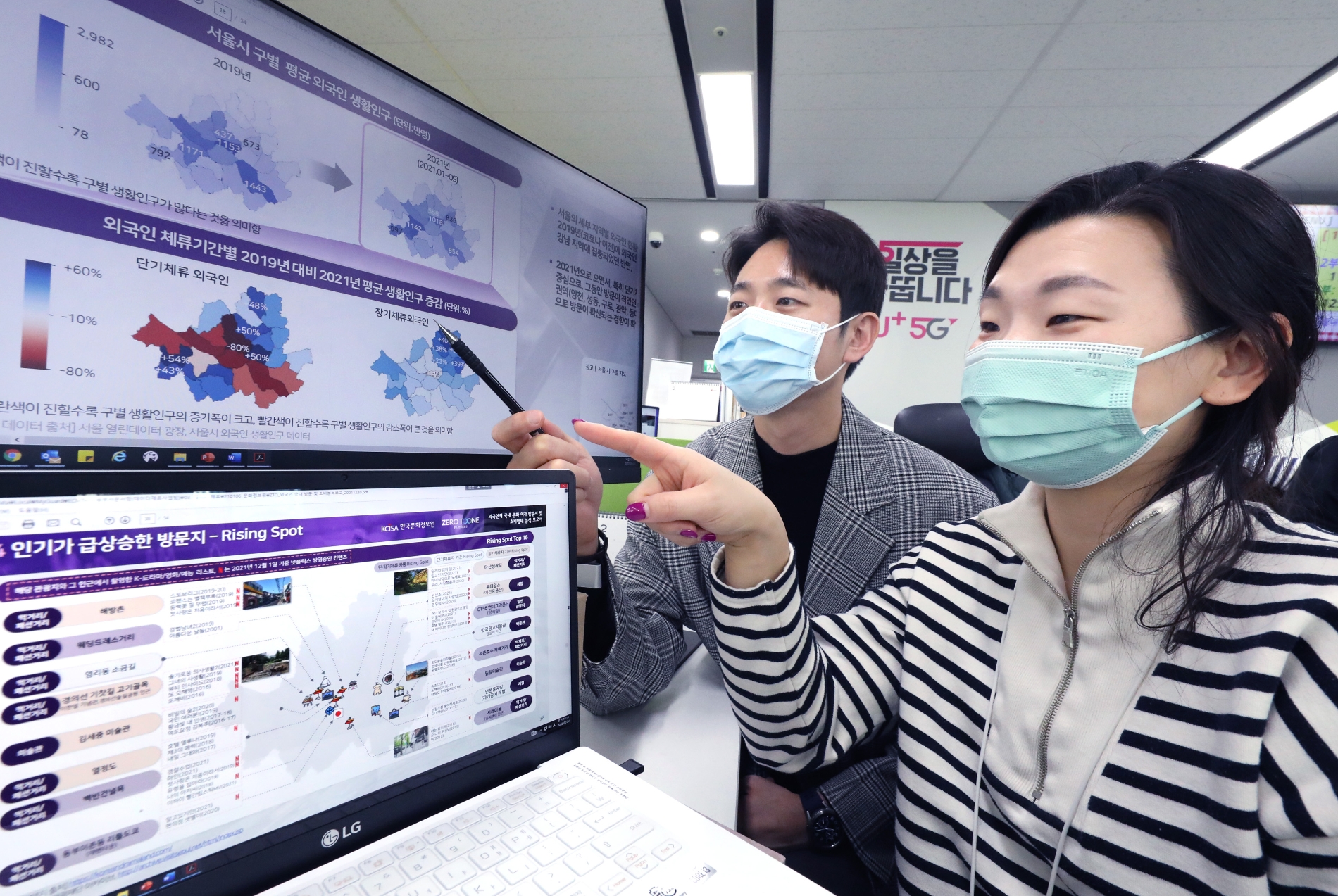 LG유플러스 직원들이 보고서에 수록된 서울시내 인기 방문지 지도를 살펴보고 있다. 사진=LG유플러스