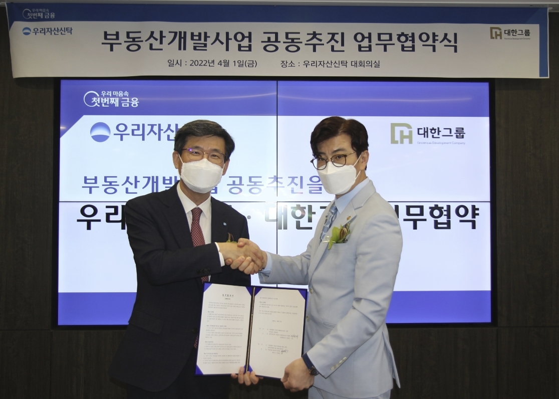 이창재 우리자산신탁 대표이사(왼쪽)가 1일 부동산개발 전문회사 대한그룹과 업무협약을 맺고 기념사진을 찍고 있다. / 사진제공=우리자산신탁