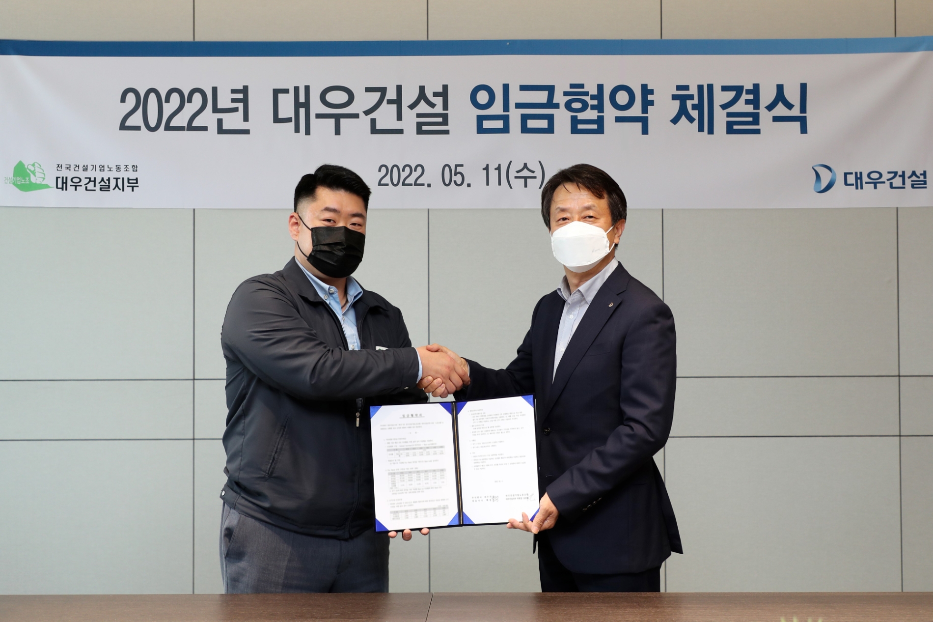 백정완 대우건설 대표이사(오른쪽)와 심상철 노동조합 위원장이 2022년 임금계약 체결식에서 악수를 나누고 있다. / 사진제공=대우건설