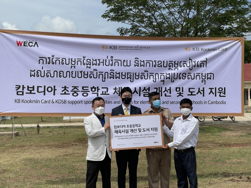 12일 캄보디아 칸달주 꼬레아루 초중등학교에서 열린 '캄보디아 초중등학교 체육시설 개선 및 도서지원' 기부금 전달식에서 이창권 KB국민카드 대표(왼쪽에서 두번째)가 행사에 참석한 관계자들과 기념촬영을 하고 있다. /사진제공=KB국민카드