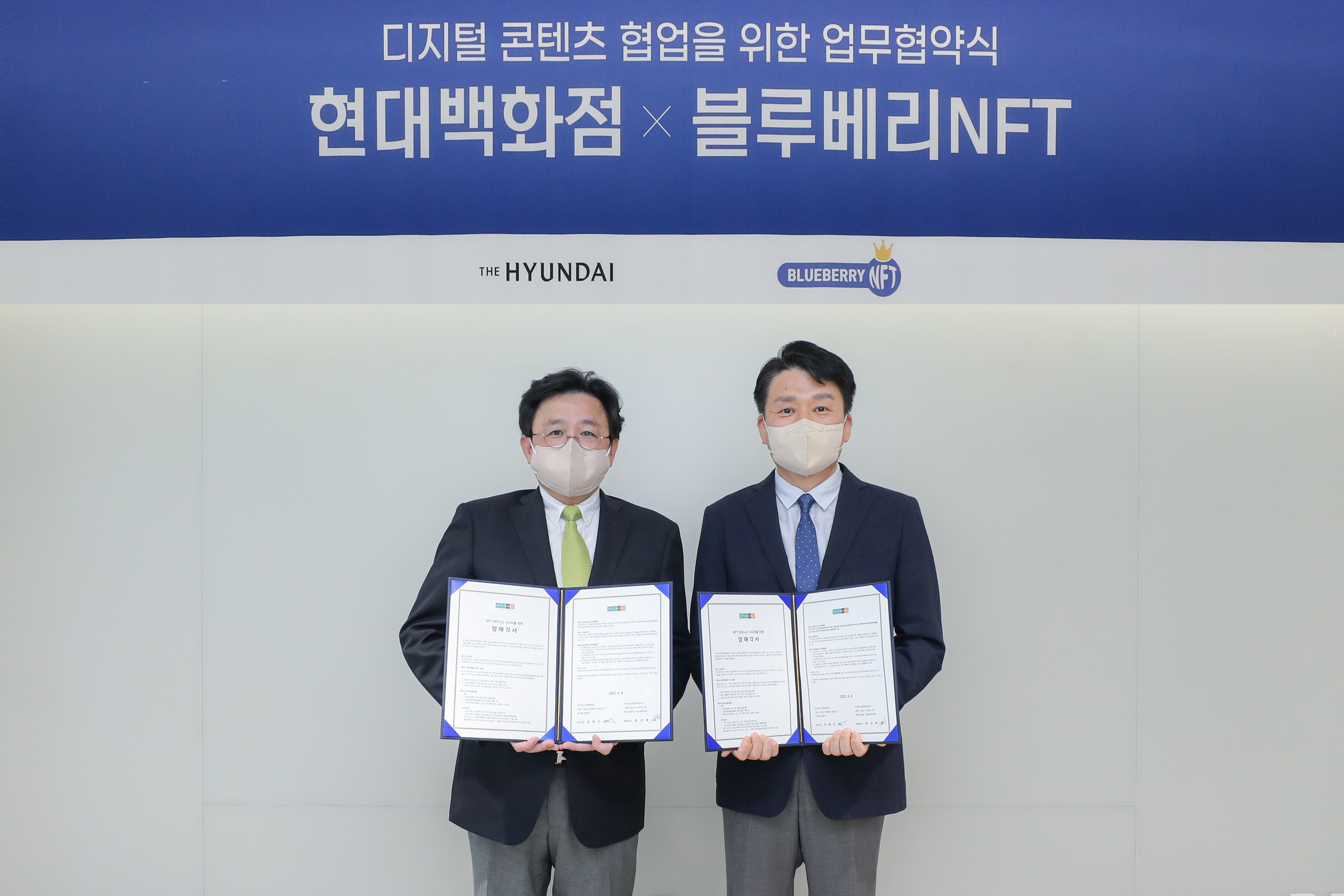 9일 서울 강남구에 위치한 현대백화점 사옥에서 권태진 현대백화점 디지털사업본부장(사진 오른쪽)과 홍상혁 블루베리NFT 대표이사(사진 왼쪽)이 MOU체결 후 기념촬영을 하고 있는 모습./ 사진제공 = 현대백화점그룹