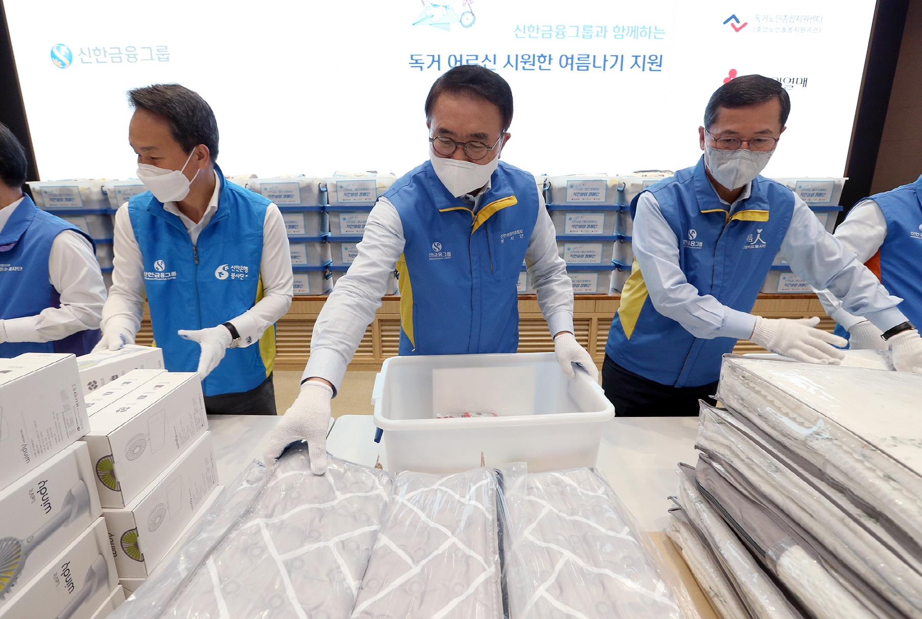 행사에 참여한 신한금융그룹 조용병 회장(사진 가운데)과 신한은행 진옥동 은행장(사진 왼쪽), 신한카드 임영진 사장이이 '독거노인 여름나기 키트'를 제작하는 봉사활동을 하고 있다. / 사진제공=신한금융그룹