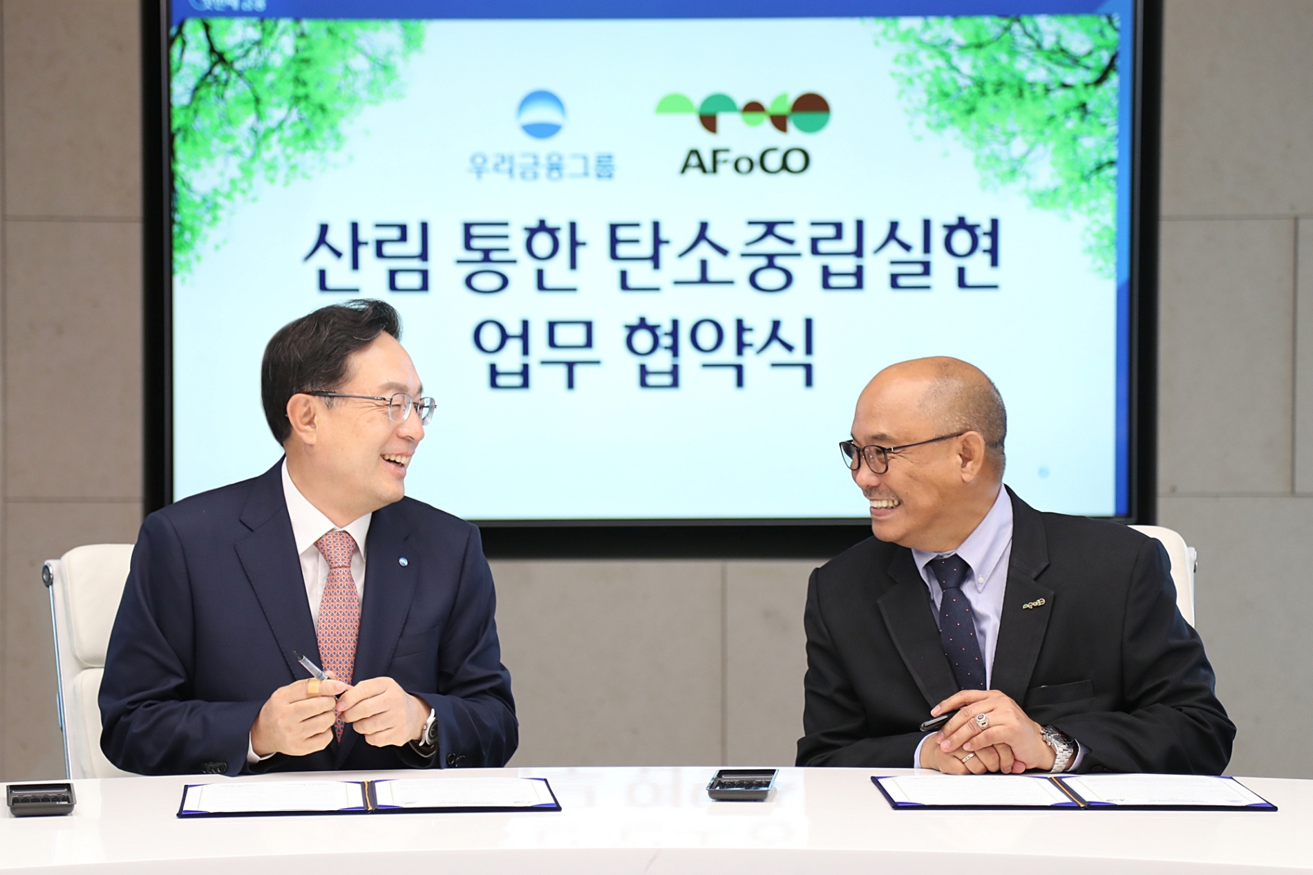손태승 우리금융그룹 회장과 리카르도 칼데론(Ricardo L. Calderon) 아시아산림협력기구(AFoCO) 사무총장이 21일 ‘지속가능한 산림관리를 통한 기후위기 대응과 ESG경영 상호협력’을 위한 업무협약을 체결하는 모습. / 사진제공=우리금융그룹
