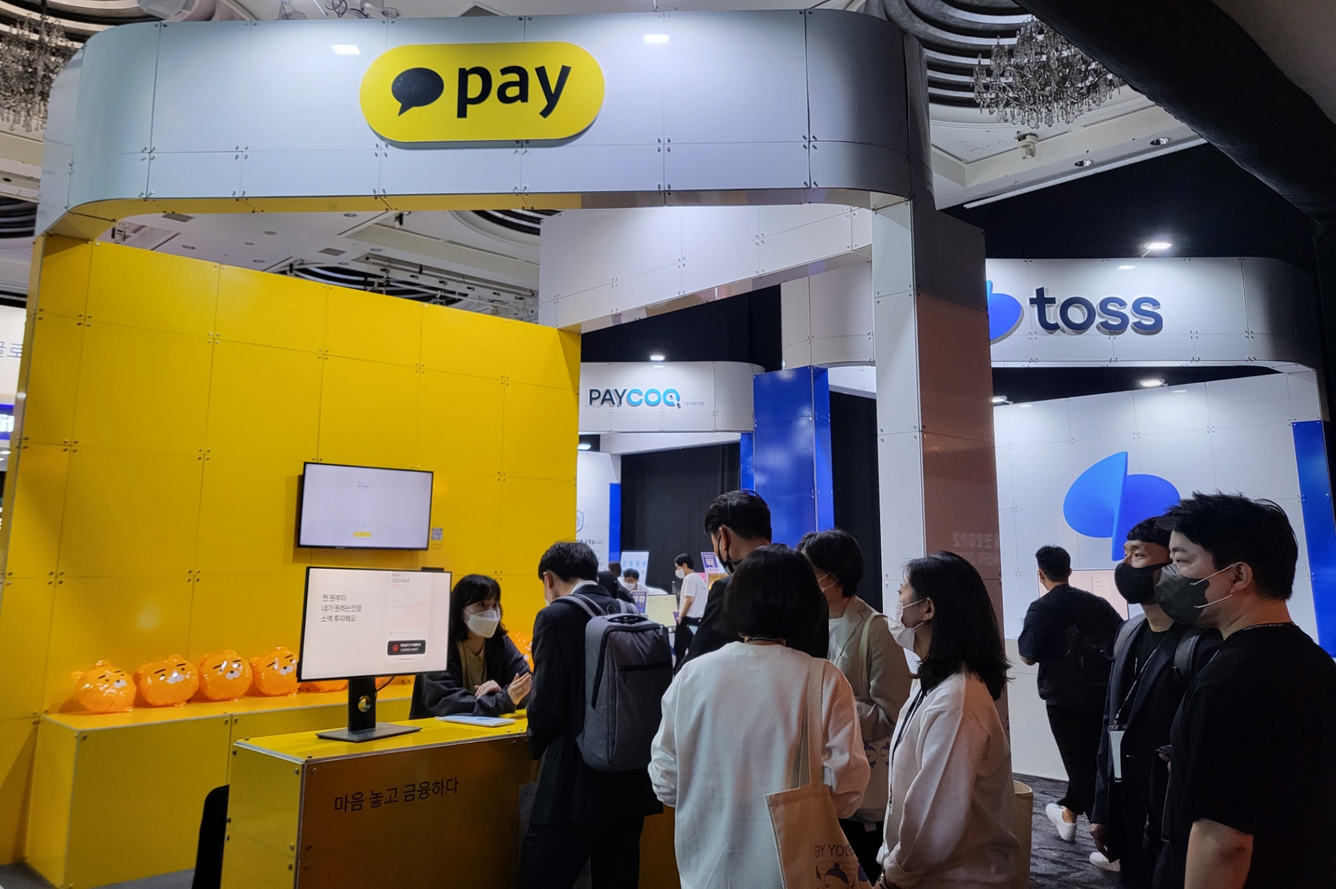 핀테크 체험관 내 카카오페이 부스에서 많은 사람들이 카카오페이 서비스에 대해 설명을 듣고 있다.
