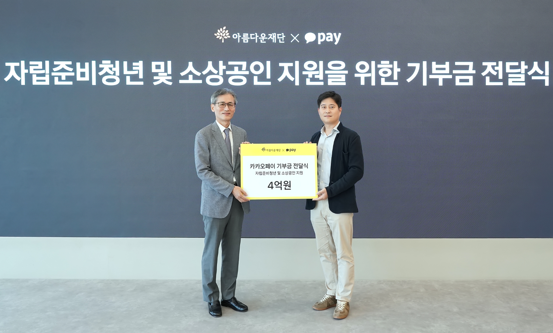 신원근 카카오페이 대표(오른쪽)가 한찬희 아름다운재단 이사장(왼쪽)에게 자립준비청년 및 소상공인 지원 기금 4억원을 전달하고 있다. /사진제공=카카오페이