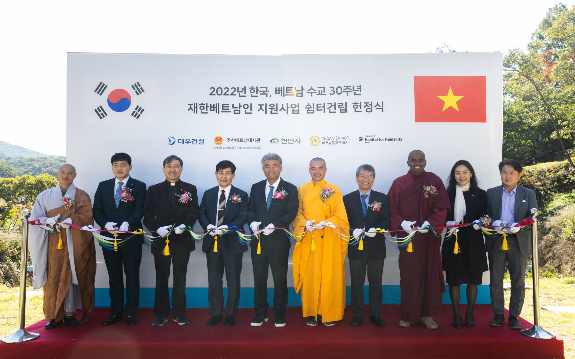 정식에 참여한 주요 인사들이 테이프 커팅을 하고 있다. 왼쪽에서부터 네 번째 해비타트 윤형주 이사장, 다섯 번째 정원주 부회장, 여섯 번째 원오사 팃 드엉 탄 주지스님, 일곱 번째 베트남 응우옌 부 뚱 대사 / 사진제공=대우건설