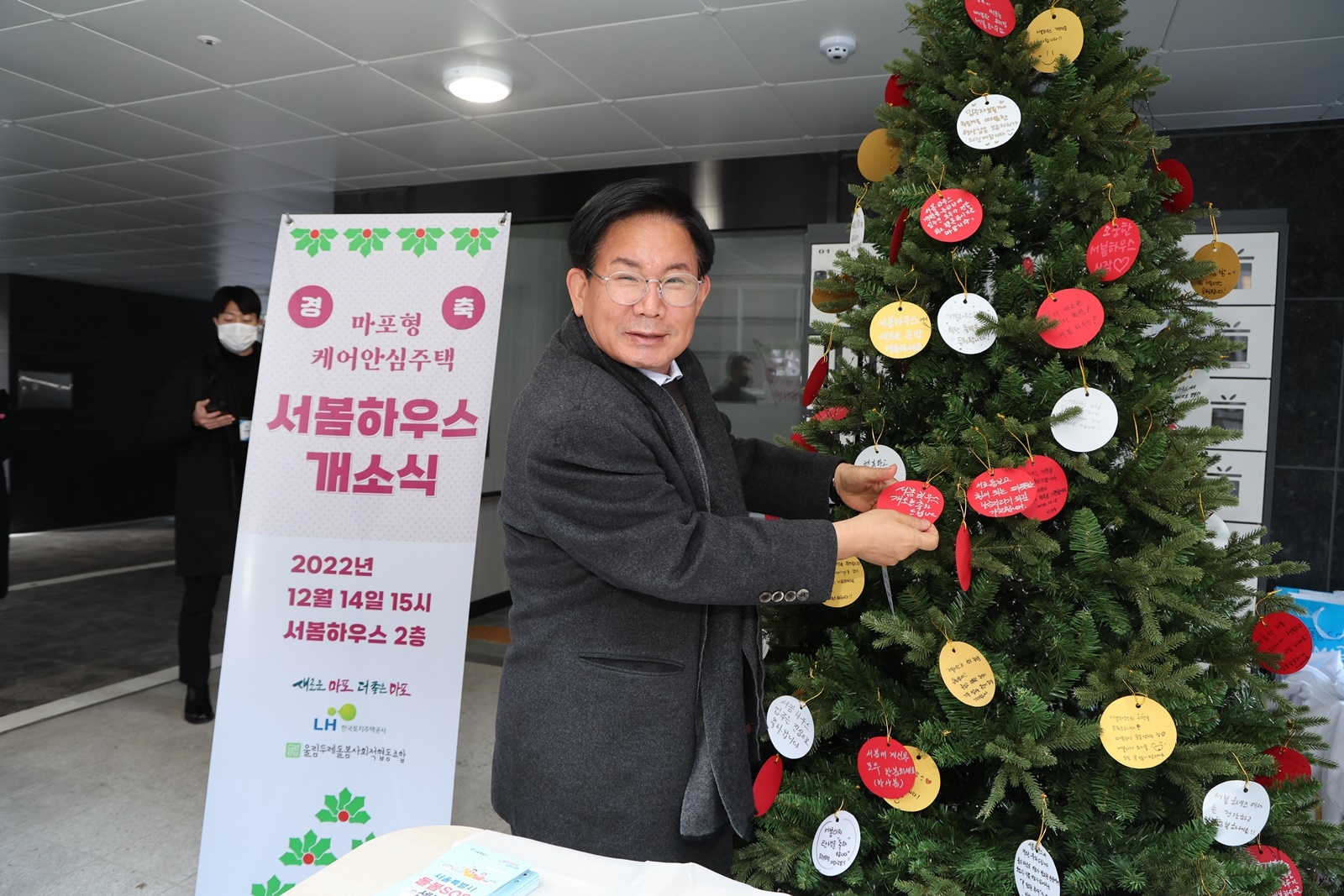 박강수 마포구청장이 서봄하우스 개소식 기념 트리에 축하메시지를 달고 있다./사진제공=마포구 