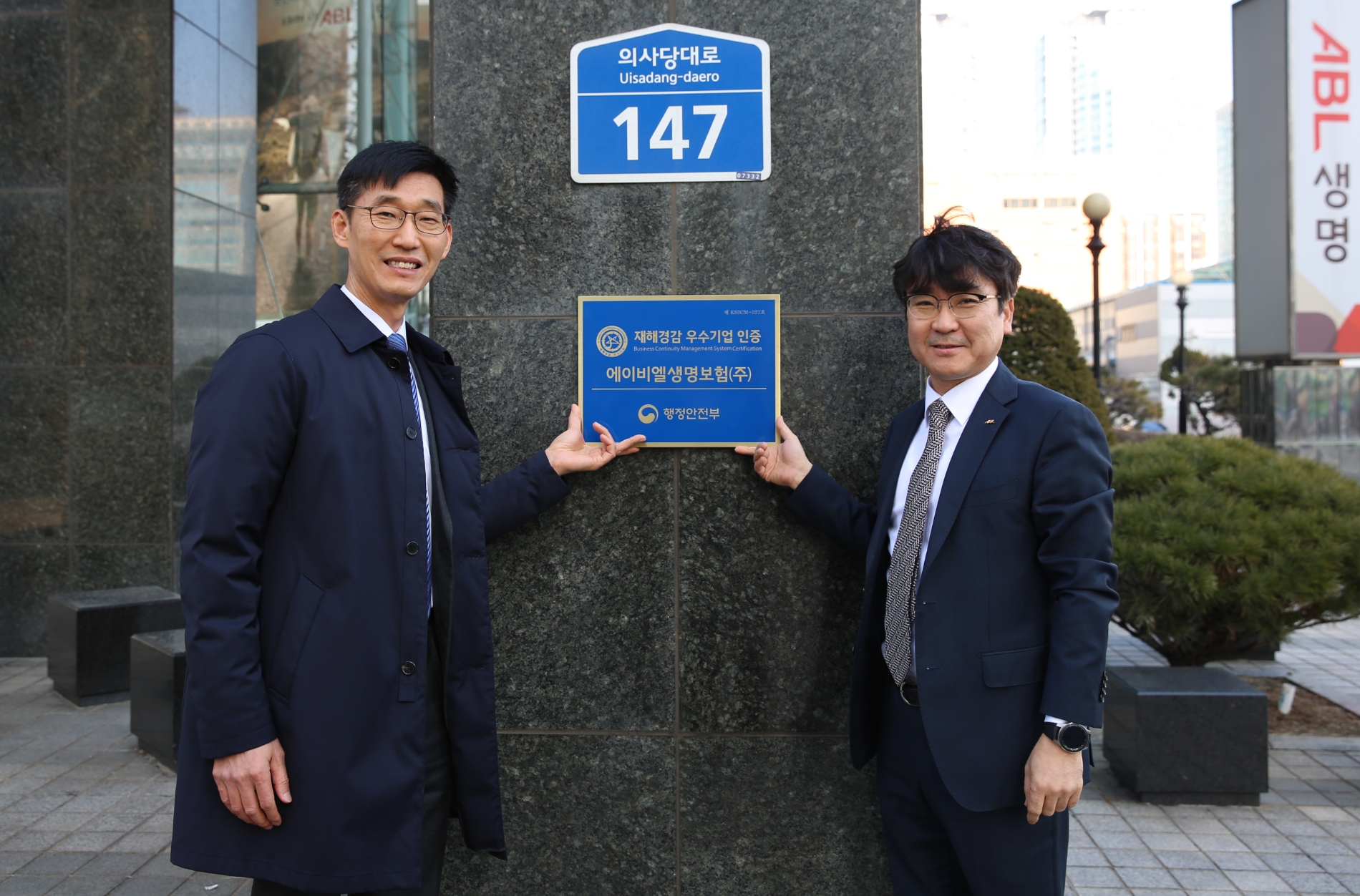 정종국 ABL생명 CRO(오른쪽)와 도준호 리스크관리부장이 행정안전부 '재해경감우수기업' 국내인증 현판식 후 기념사진을 촬영하고 있다./사진=ABL생명