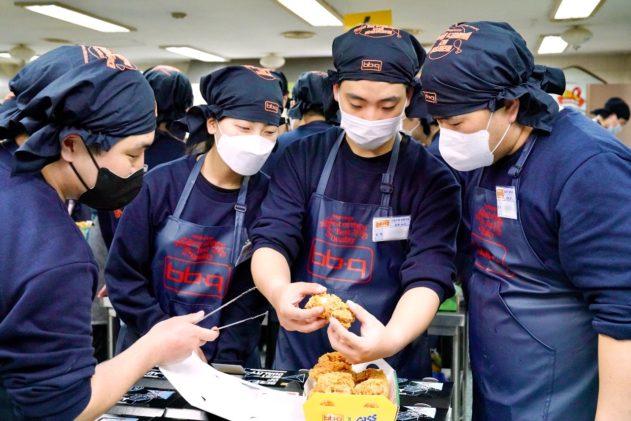 제너시스BBQ 그룹 2023년 신입사원들이 치킨대학에서 제품 오퍼레이션 교육 중에 만든 치킨을 서로 품평하고 있다./ 사진제공 = 제너시스BBQ