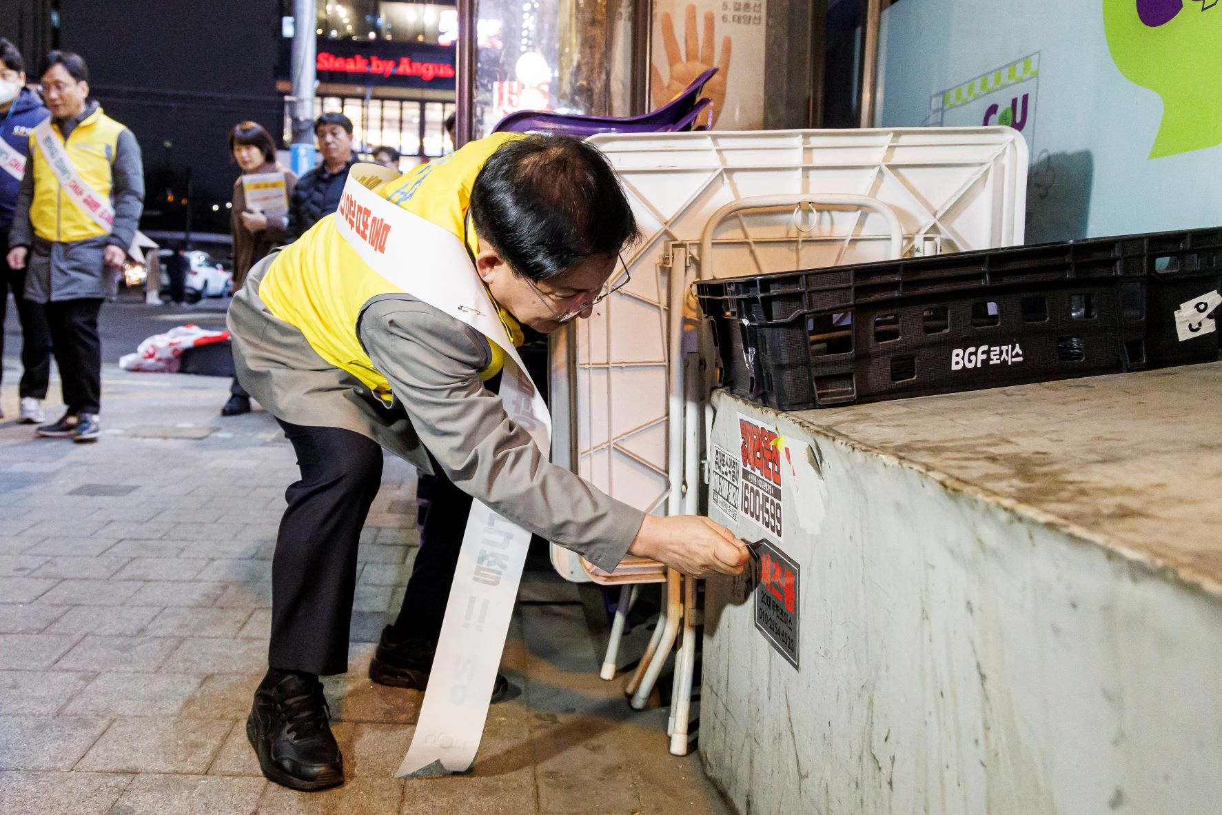 박강수 마포구청장 벽면에 부착된 셔츠룸 스티커를 제거하는 모습./사진제공=마포구