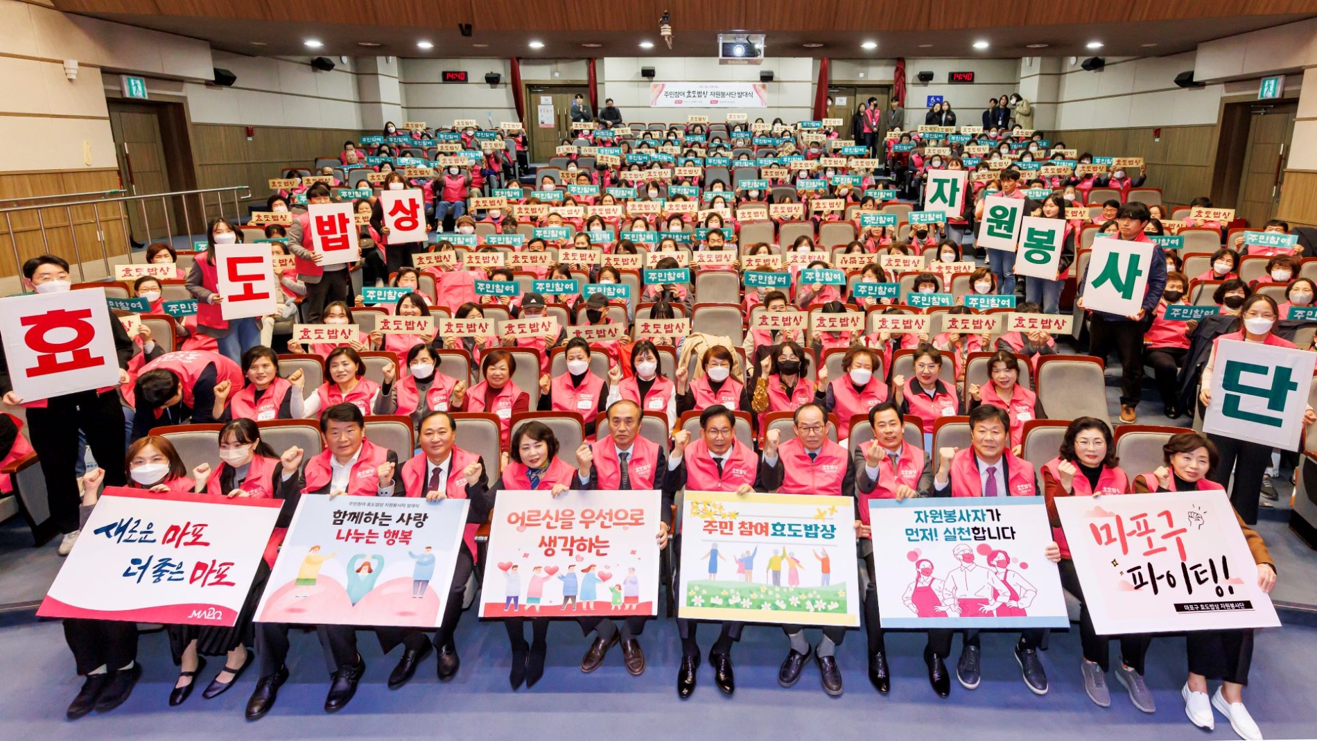 박강수 마포구청장(앞줄 가운데)과 효도밥상 자원봉사단이 사업의 성공적인 추진을 기원하는 카드섹션 이벤트를 하고 있다.사진제공=마포구