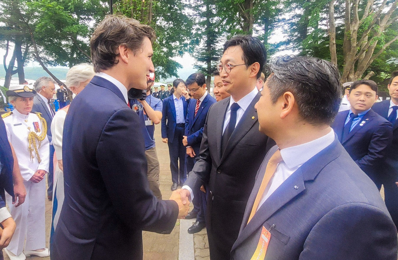 지난 18일 경기도 가평군 참전비 경내에서 열린 ‘캐나다 참전 가평전투지 숲길 조성’ 기념식에서 쥐스탱 트뤼도 캐나다 총리와 이동훈 아워홈 부사장(가운데)이 인사를 나누고 있다./ 사진 = 아워홈