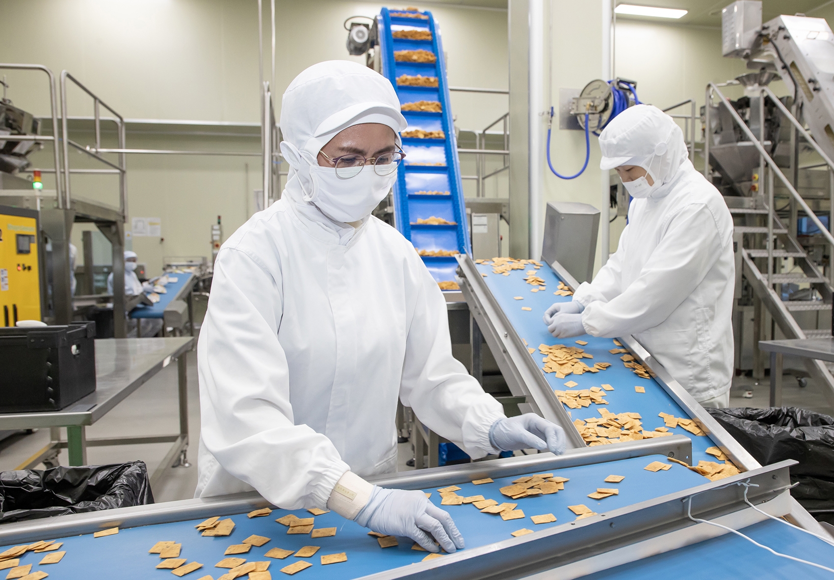 전라남도 여수에 위치한 식품기업 '쿠키아'에서 삼성전자 스마트공장 담당자(오른쪽)과 쿠키아 직원이 두부과자 품질 상태를 점검하고 있다. 사진 제공=삼성전자