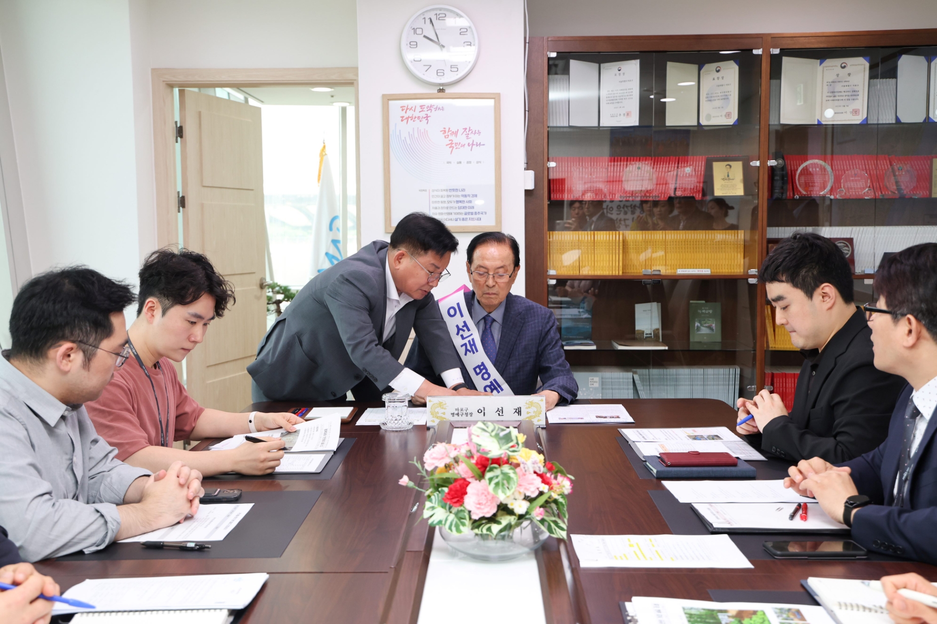 박강수 마포구청장(가운데 왼쪽)과 이선재 명예구청장이 5월31일 구청 정책회의실에서 마포부 직원들에게 민원보고를 받고 있다./사진제공=마포구