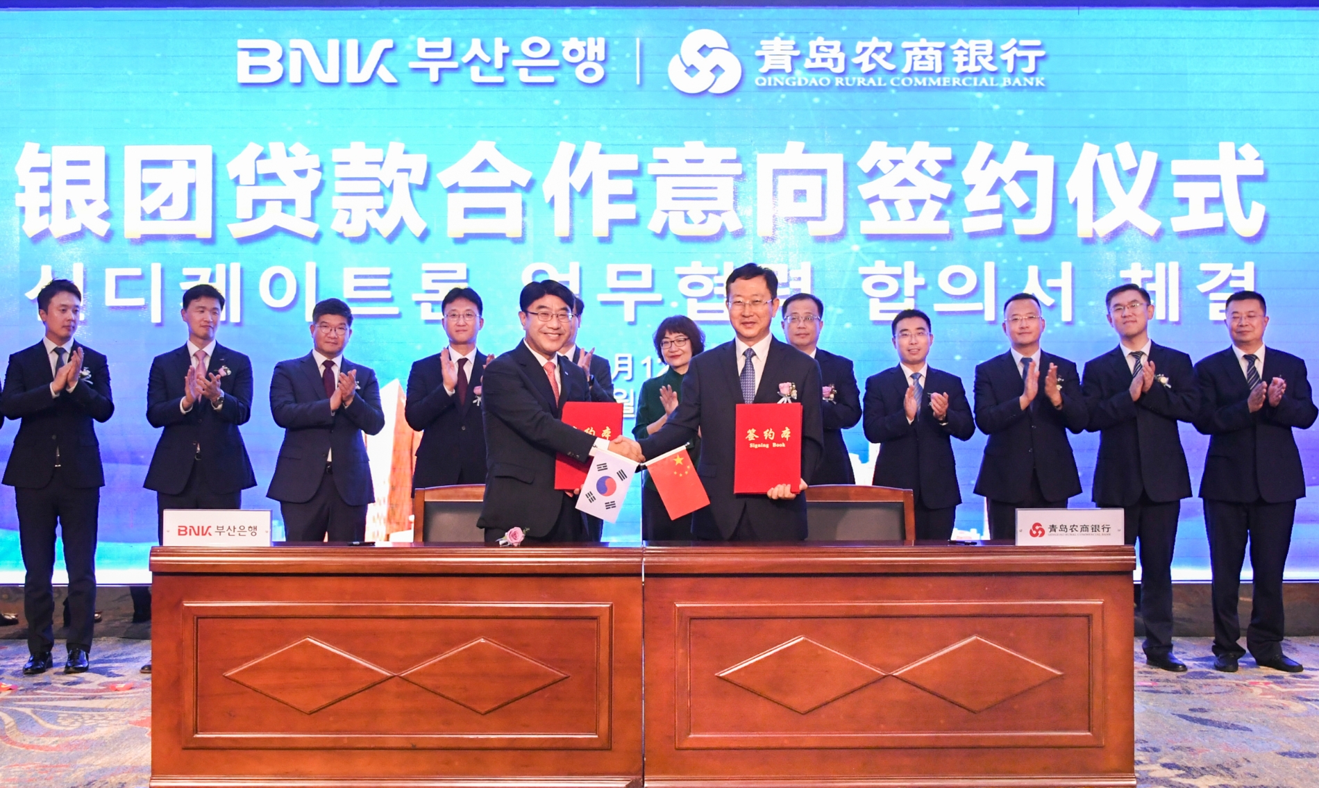 방성빈 BNK부산은행 은행장(왼쪽)과 우풍성 칭다오농상은행장(오른쪽)이 지난 12일 오후 중국 칭다오농산은행 본점에서 중국영업점 영업력 강화를 위해 전략적 업무협약을 체결했다. /사진제공=BNK부산은행