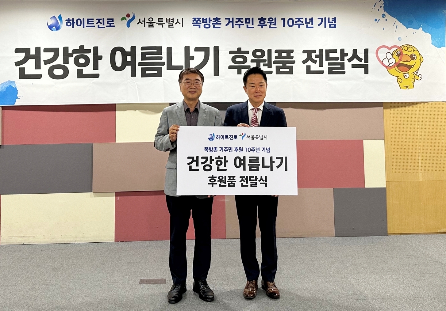 하이트진로 장인섭 전무(오른쪽), 서울시 복지정책실 김상한 실장(왼쪽) 등 관계자가 참석한 가운데 서울시청에서 ‘건강한 여름나기’를 위한 후원품 전달식을 가졌다./ 사진 = 하이트진로