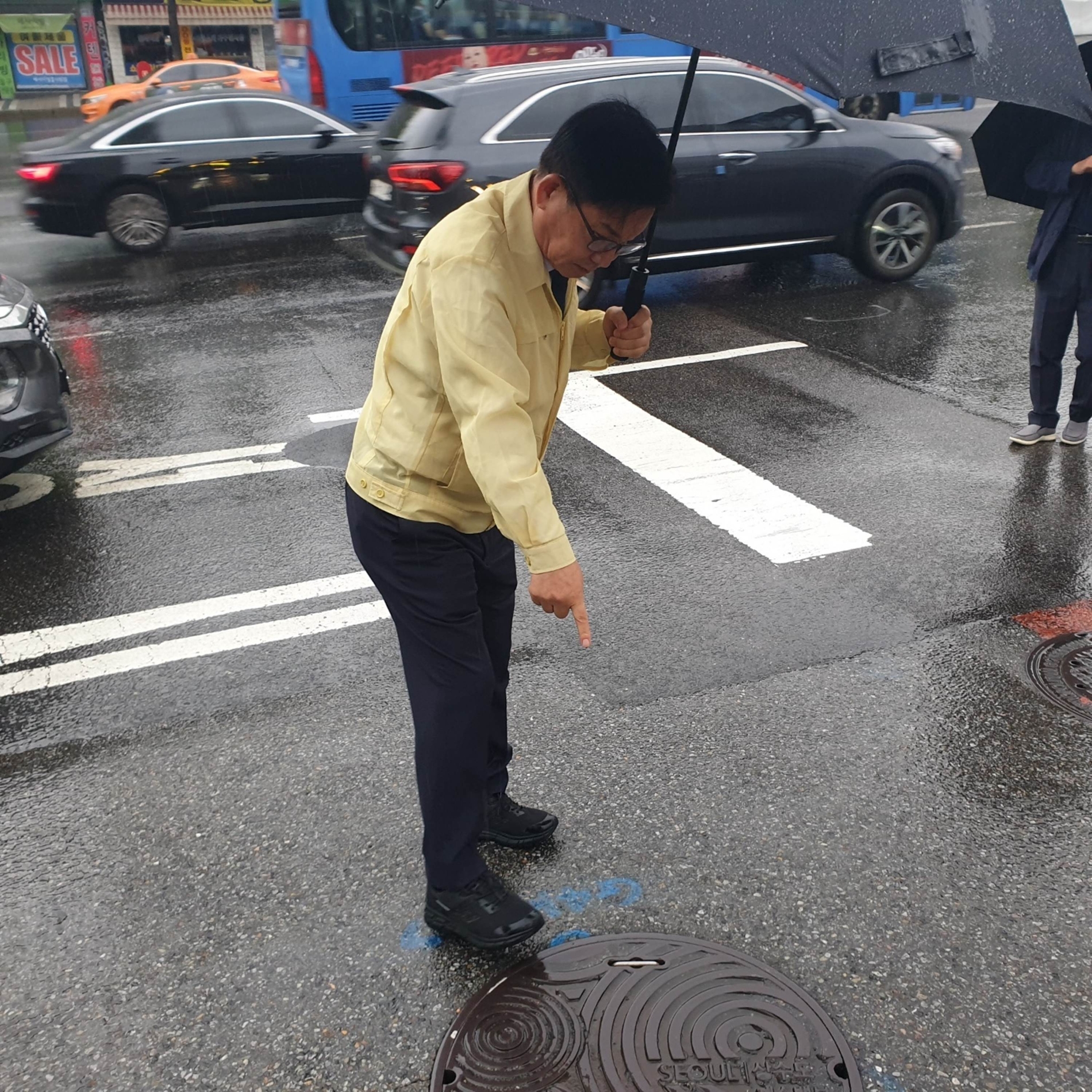 박강수 마포구청장이 집중호우에 대비해 도로의 맨홀을 점검하는 모습./사진제공=마포구