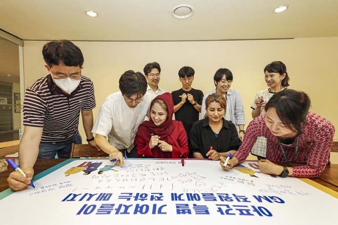 아프간 특별 기여자와 GM 임직원들이 서로에게 응원의 메시지를 써주고 있다. 사진=한국GM.