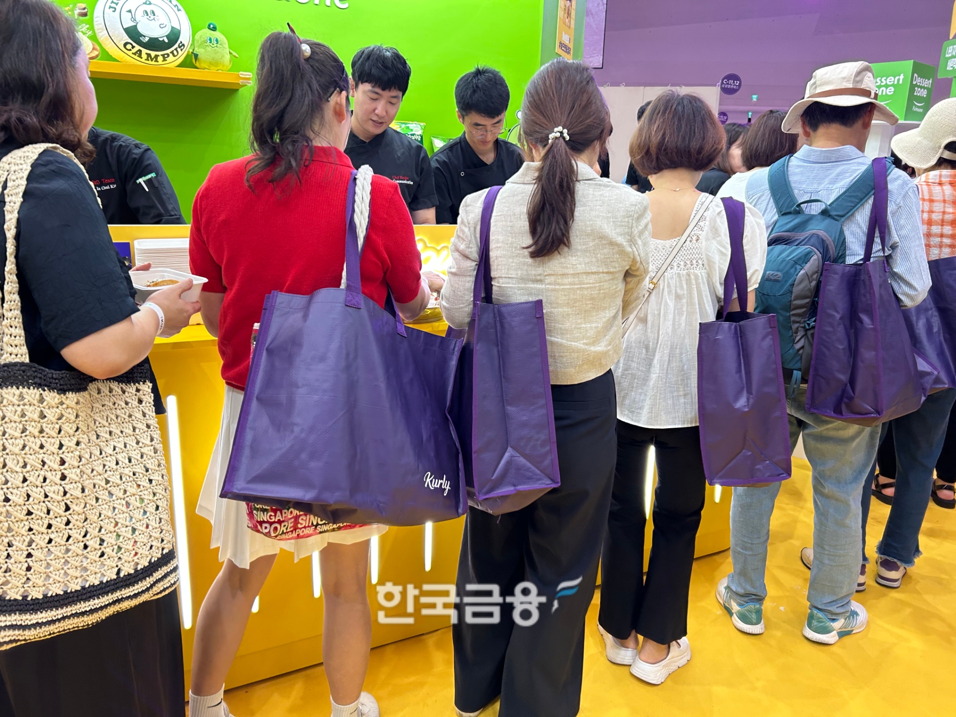 보라색 컬리 장바구니를 메고 줄을 길에 선 사람들의 모습. /사진=박슬기 기자