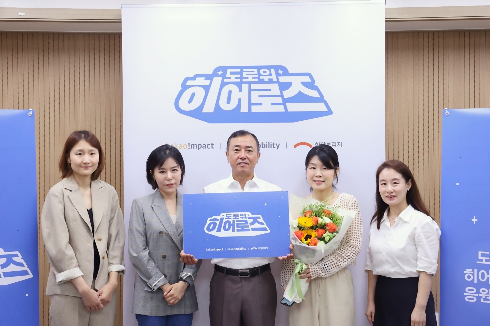 도로 위 히어로즈로 선정된 4인의 버스 기사 중 일본인 관광객이 잃어버린 800만원과 비행기표를 찾아 돌려준 사연으로 도로 위 히어로즈로 선정된 이성문 기사(가운데)가 카카오모빌리티, 카카오임팩트, 희망브리지 관계자들과 함께 기념촬영을 진행하고 있다. / 사진제공=카카오모빌리티