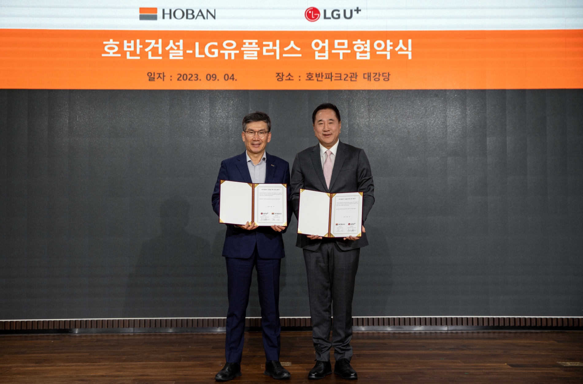 문갑 호반건설 경영부문장(왼쪽)과 현준용 LG유플러스 EV충전사업단장이 협약을 체결하고 기념촬영을 하는 모습./사진제공=호반건설