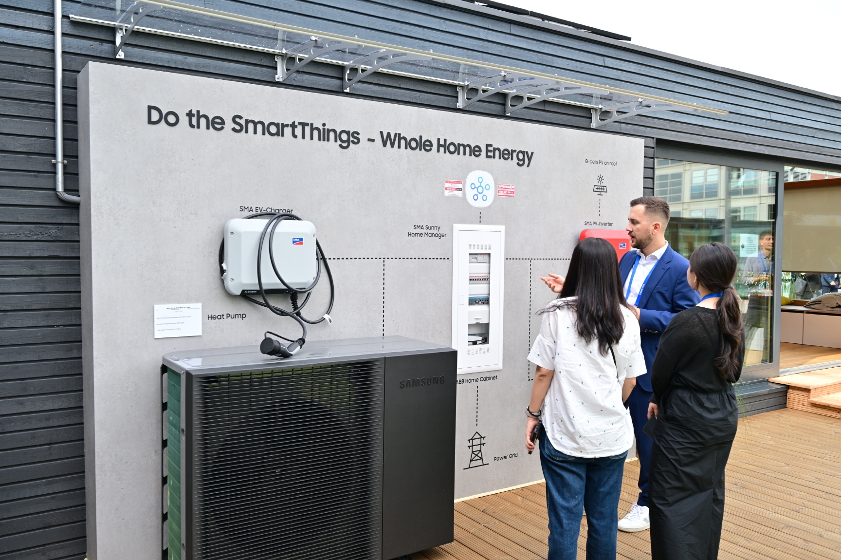 삼성전자 직원이 넷 제로 홈(Net Zero Home)' 솔루션으로 꾸며진 타이니 하우스 외관에 소개된 SMA와 ABB의 에너지 생산/저장 시스템을 소개하고 있다./사진제공=삼성전자