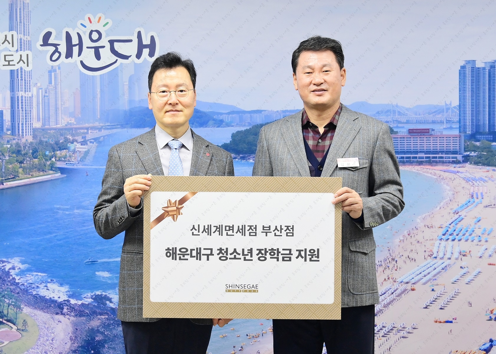 한세경 신세계면세점 부산점장(왼쪽)과 김성수 해운대구청장이 지난 12일 부산 해운대구청에서 열린 해운대구 청소년 장학금 증정식에서 기념촬영을 하고 있는 모습. /사진제공=신세계면세점