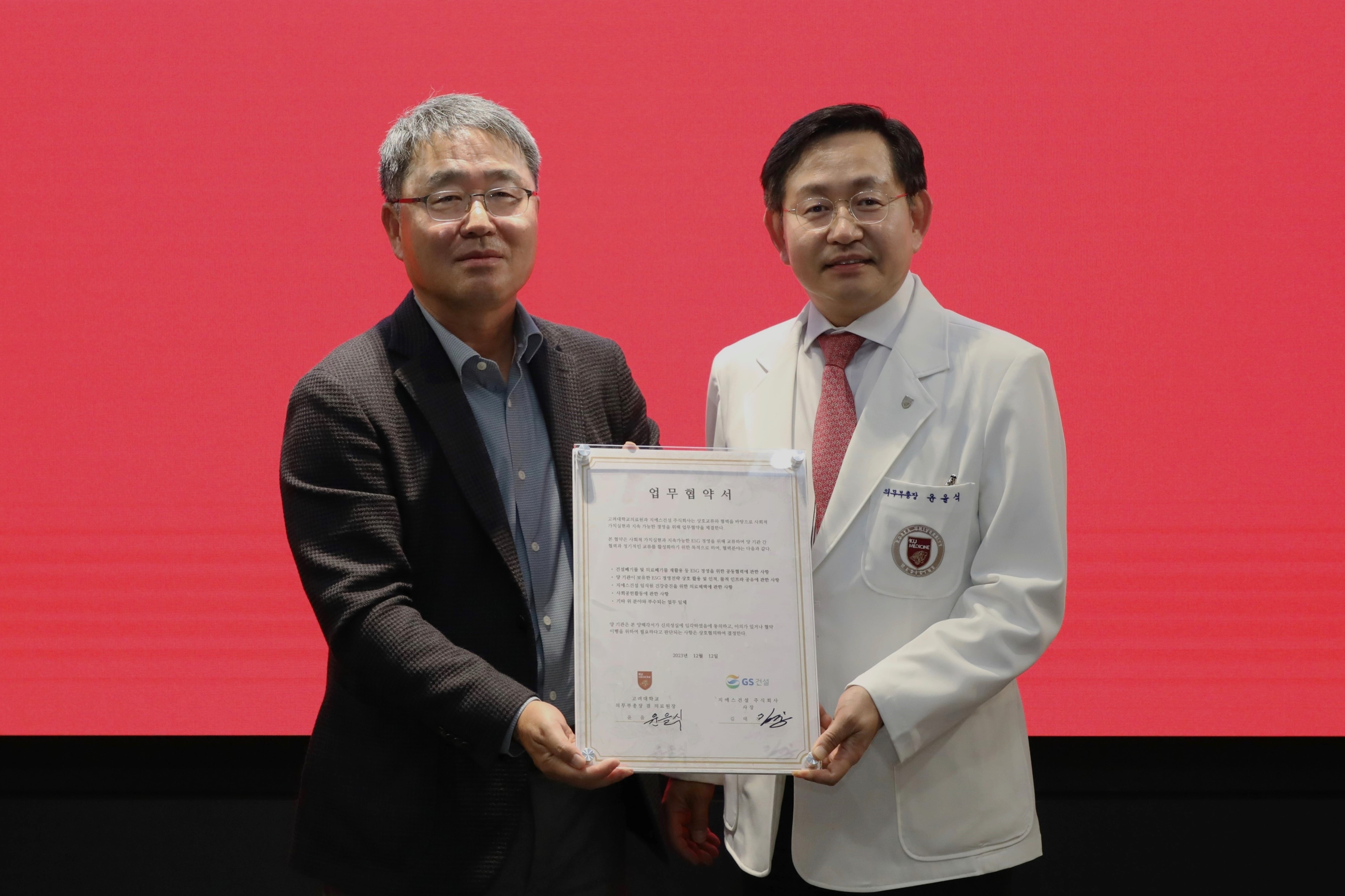 GS건설 경영지원본부장 김태진 사장(왼쪽)과 고려대학교의료원 윤을식 의무부총장이 폐안전모를 재활용한 업무협약패를 들고 기념사진을 촬영하고 있다./사진제공=GS건설