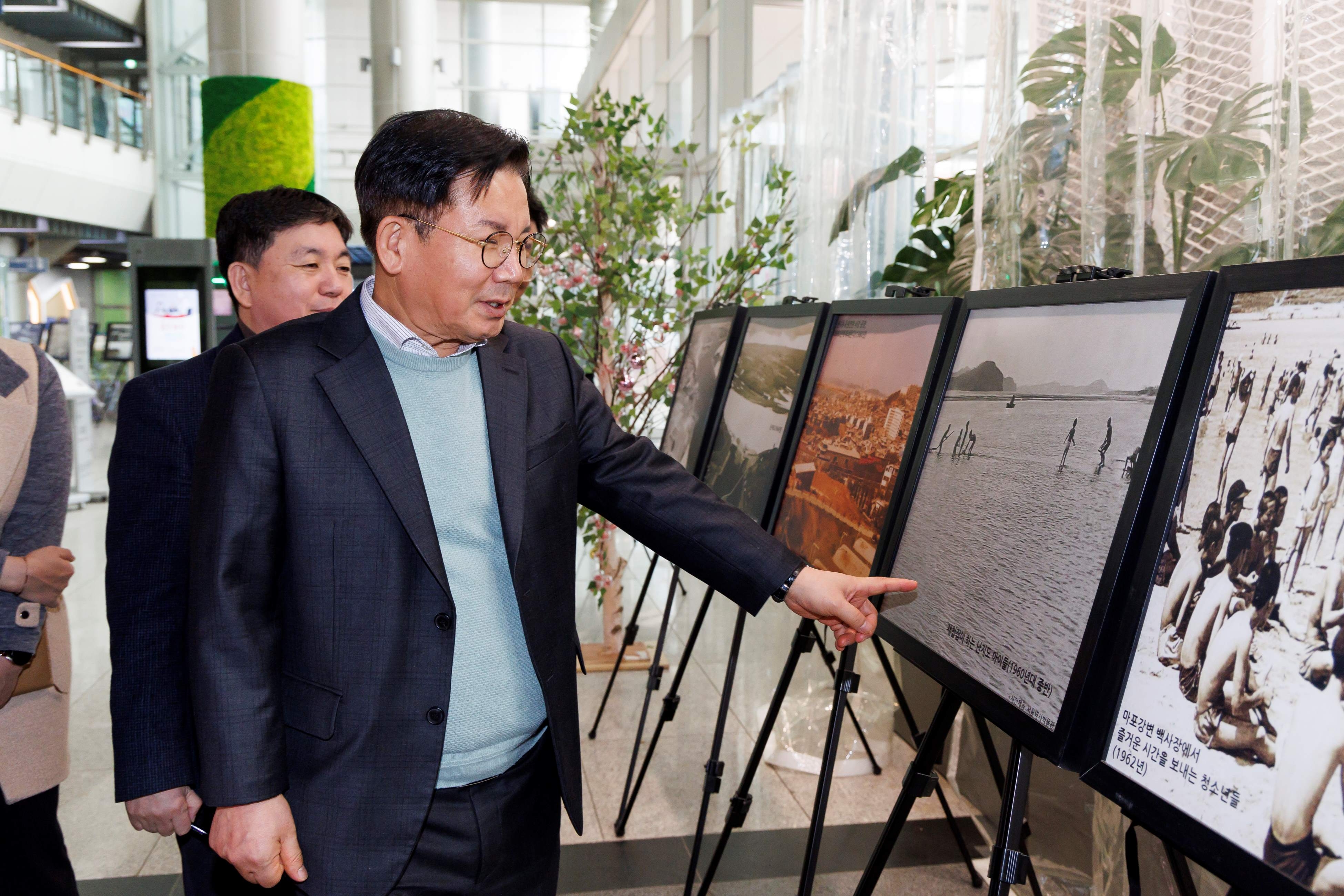 박강수 마포구청장이 구청 로비에 마련된 '마포구 옛 사진'을 살펴보는 모습./사진제공=마포구