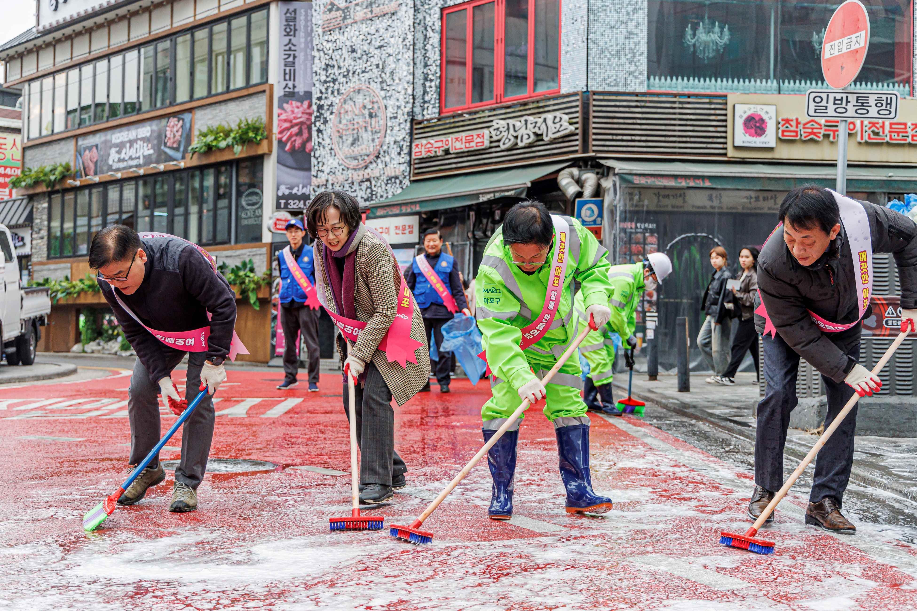 박강수 마포구청장이 공무원들과 함께 물청소를 하는 모습./사진제공=마포구