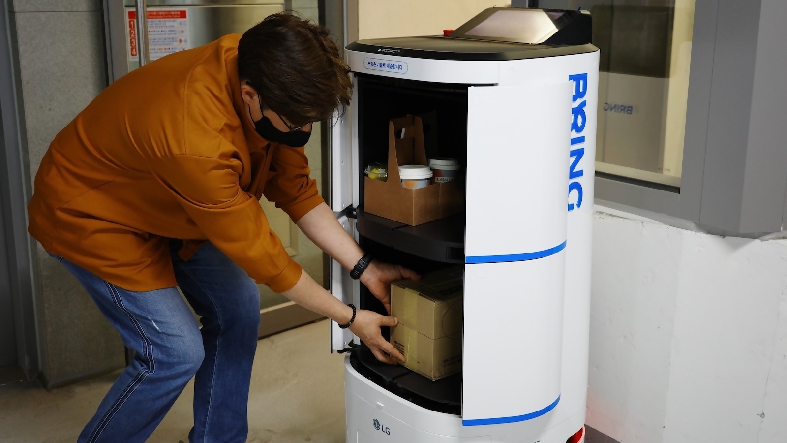 브링 서비스를 이용하기 위해 직원이 배송 로봇에 소포를 싣는 모습. / 사진제공=카카오모빌리티